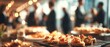 © abdul kahfi - Buffet food with appetizers and blurry background of people during social gathering