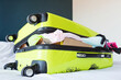 © Алина Бузунова - Overstuffed lime green suitcase on a bed with clothes and items spilling out