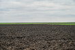 © Ajdin Kamber - Freshly plowed field ready for seeding and planting. Empty plowed land in Romania. Black soil.