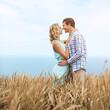 © ReeseFullyOwned/peopleimages.com - Love, couple and smile in field for romance, date and hug with environment on holiday. Support, man and woman in countryside with wheat on vacation for commitment, bonding and together outdoor