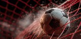 Soccer ball powerfully strikes red net, creating a dramatic impact of dust and spray