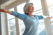 © Artinun - Senior woman doing balance training exercise with simple movements indoors at home, elderly fall prevention and healthy aging concept showing steady focus, physical wellness and medical rehabilitation