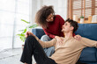 © Kawee - Latina young couple sitting together on sofa in living room at home.