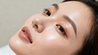 © ibhonk - Young adult Asian woman's healthy face featuring glowing, dewy skin and soft pink glossy lips with slight perspiration visible.
