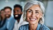 © Deepwood - Smiling businesswoman with colleagues in the background, looking at the camera