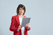 © Stock 4 You - Focused middle aged businesswoman using touchscreen pc for office investment work. Mature ceo professional business leader executive woman in red blazer working isolated on tablet computer. Copy space