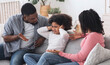 © Prostock-studio - Family Upbringing Concept. Small african kid girl covering ears not to listen parents scolding, disobedient child ignoring father's words