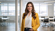 © Vyatcheslav - Portrait of a confident young businesswoman smiling in a modern office. Successful female professional in a yellow blazer looking at the camera