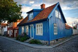 A charming and vibrant wooden house, adorned with striking blue walls and a bold red roof, stands proudly on a quaint street during a breathtaking sunset in a picturesque historic town