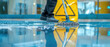 © petrrgoskov - Close-up of professional cleaner mopping wet shiny floor in modern public building with warning sign in background, hygiene, sanitation, safety and maintenance service concept.