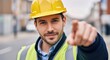 © IbragimovN - Confident construction worker pointing forward in urban setting with yellow hard hat