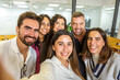 © Juan Algar - Group of colleagues taking a selfie in a modern coworking space