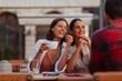 © Novak - Group of diverse friends hanging out in a coffee shop with focus on two happy girls