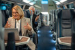 © Jelena - Senior businesswoman participating video call traveling train