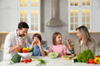 © New Africa - Happy family cooking together at table in kitchen