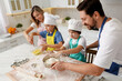 © New Africa - Happy family cooking together at table in kitchen