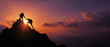 © Anoo - Colleagues stand together on a mountaintop at sunset, silhouetted as one person helps another reach the top with bright colors in the sky