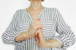 © tanyatorgonskaya - Woman grasping one hand with the other, demonstrating a self-massage and finger-stretching technique. Symbolizes muscle relaxation, tension release exercise, and circulation stimulation method.