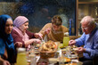 © .shock - Family gathers for iftar meal during Ramadan while sharing food and stories at a warm gathering space in the evening