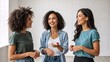 © Vasiliy - Three happy diverse young women talking and laughing together. Group of female friends standing and chatting in a bright room