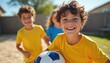 © Vadym - Three children smile, play soccer in a sunny backyard. Boys wear yellow shirts, girl in blue. Friends enjoy game day on green grass. Active kids learn teamwork, have fun outdoors.