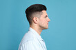 © New Africa - Profile portrait of man on light blue background