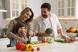 © New Africa - Happy family cooking together at table in kitchen