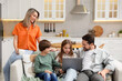 © New Africa - Happy family with laptop spending time together on sofa in kitchen at home