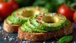 © Viktor - Open faced avocado toast topped with chili flakes and coarse sea salt. Sliced avocado on whole grain bread with fresh tomatoes and basil leaves for a healthy meal.