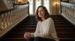 © Muhammad - Contemplative young woman perched elegantly on a grand staircase amidst architectural grandeur