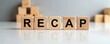 © Maryna - Wooden blocks spell out RECAP on reflective white surface against blurred gray background. Stacked blocks suggest organization or building process. Visualizes summarization for business or education.