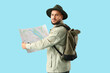 © Pixel-Shot - Male traveler with map on blue background. Search concept
