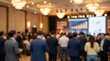 © Bongopi  - Business people attend conference presentation in large meeting room with projector screen and chandeliers
