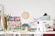 © Pixel-Shot - Tailor's workplace with sewing machine and thread spools in workshop