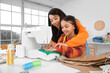 © Pixel-Shot - Happy Asian mother and her daughter sewing toys in workshop