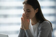 © fizkes - Praying for solution. Close up portrait young woman student freelancer employee with closed eyes sit by notebook hold hands clasped make secret wish whisper inner prayer in mind ask destiny for help