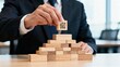 © Serene‌ - Businessman stacking wooden blocks