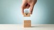 © Al - Hand placing wooden block with locked lightbulb drawing on another block, concept of security, idea protection, or unlocking potential
