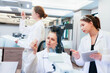 © ultramansk - Diverse team of female scientists working in busy digital pathology lab. Researchers analyzing histology slides using microscope, tablet, and visual inspection for medical diagnosis.