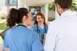 © StockMe - Medical team members with a doctor and two nurses in scrubs having an outdoor discussion at a hospital, demonstrating healthcare teamwork and collaboration in medicine