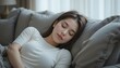 © Aodsy - Young woman resting peacefully on cozy sofa with soft pillows