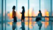 © ryker - Blurred office interior at sunrise with three business people talking and working in bright spacious meeting area conveying calm professional collaboration