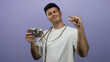 © Krakenimages.com - Hispanic man in white shirt making small size gesture with fingers while holding vintage camera against isolated purple background.