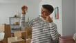 © Krakenimages.com - Young man smiling while holding key in new apartment surrounded by boxes symbolizing home ownership and moving with joy and optimism in a modern living space.