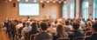 © Macrostock - Audience with blurred speaker giving presentation in bright university workshop lecture hall background. Scientific conference presentation event, training, meeting. High quality