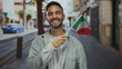 © Krakenimages.com - Young man smiles holding an italian flag on a city street, capturing a vibrant urban scene outdoors with cultural pride.