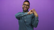 © Krakenimages.com - Young hispanic man wearing glasses and denim shirt showing hands making peace sign and smiling in a purple studio; joyful celebration.