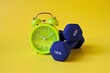 © Isman - blue barbell and alarm clock on yellow background
