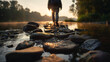 © hestywinarni - Man walking on stones in water along a natural stone path during sunset