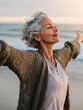 © Johannes - happy mature woman with arms outstretched feeling the breeze at beach beautiful middle aged woman with arms up dancing on beach mid lady feeling good and enjoying freedom at sea copy space no logos n